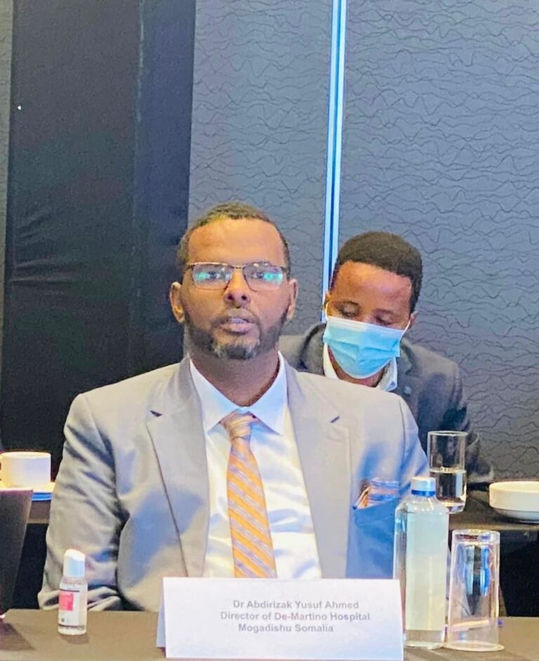 Dr Jalaaludiin seated at a conference table during a professional global health event.